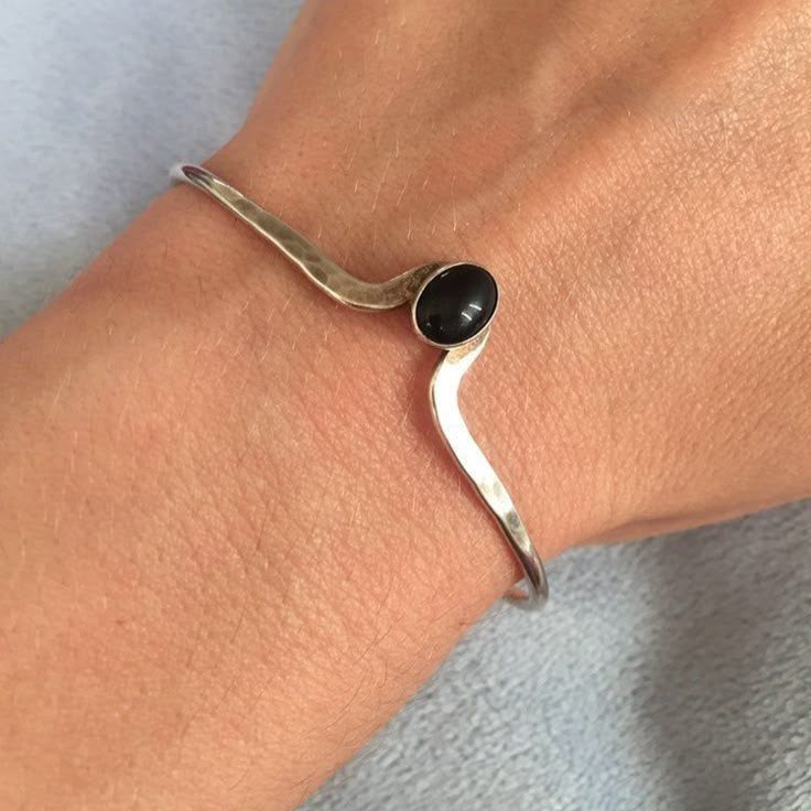Sølvfarvet armbånd med sort sten