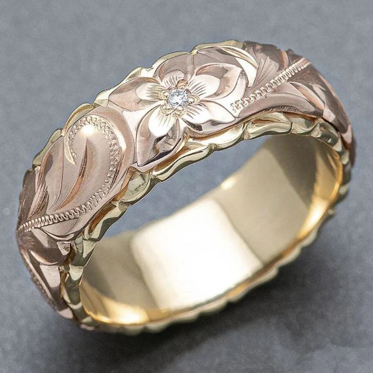 Gylden ring med rosa blomsterelementer